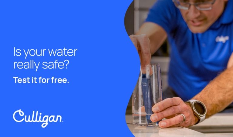 Culligan representative performing a free water safety test with a TDS meter in a glass of water, accompanied by the text 'Is your water really safe? Test it for free.